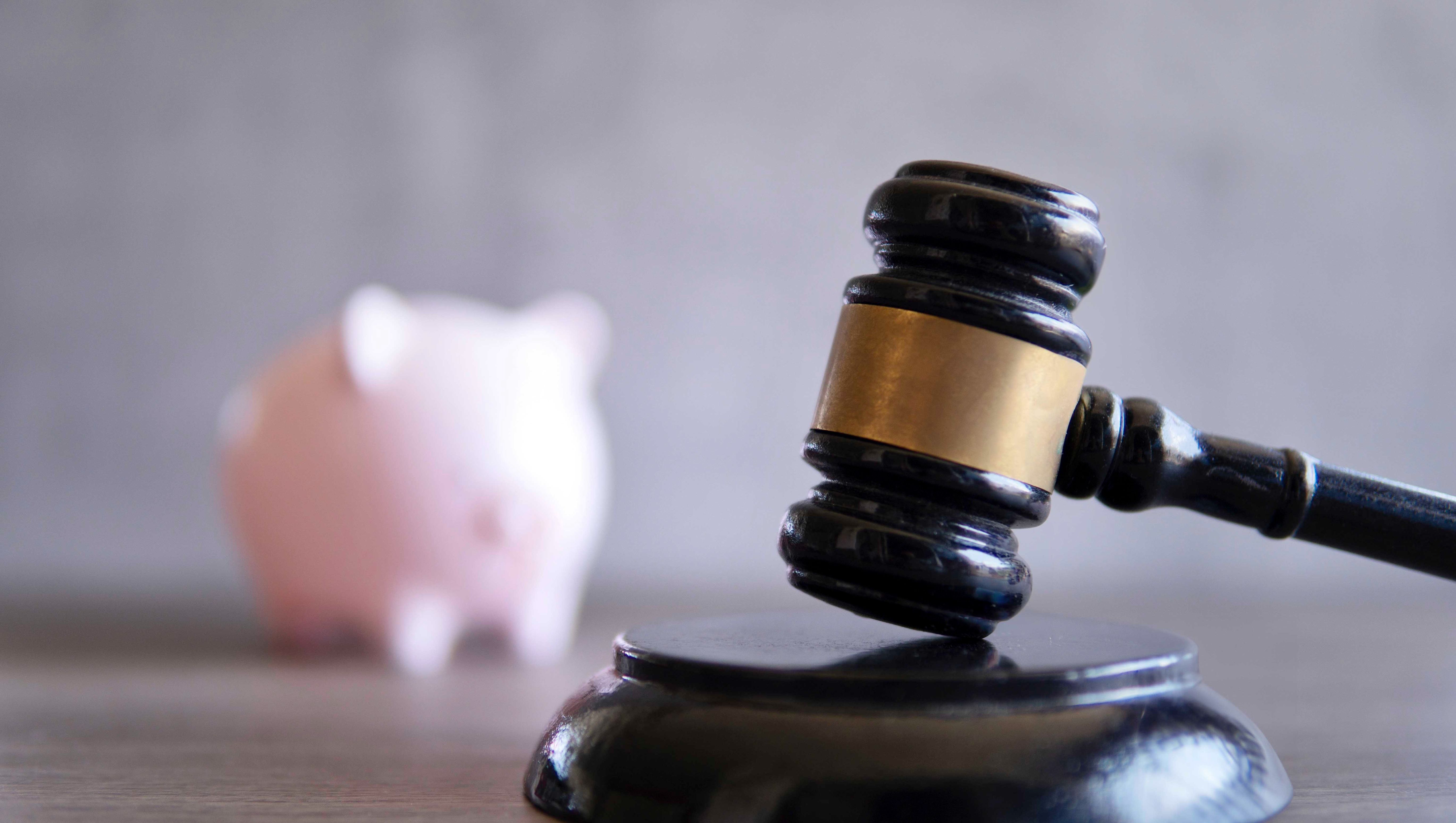 Nahaufnahme von Richterhammer und Sparschwein. Konkurs, Insolvenz und Finanzkonzept.